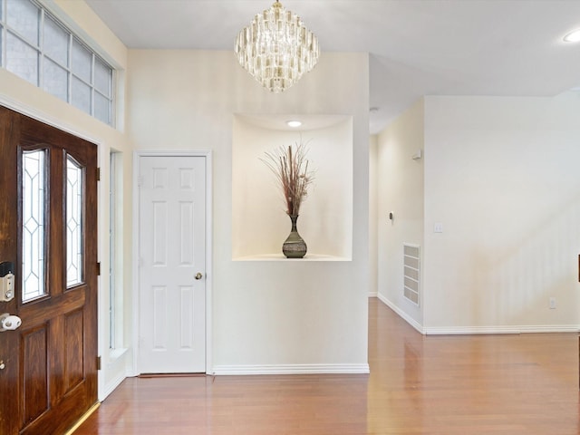 entrance foyer featuring hardwood / wood-style floors and an inviting chandelier