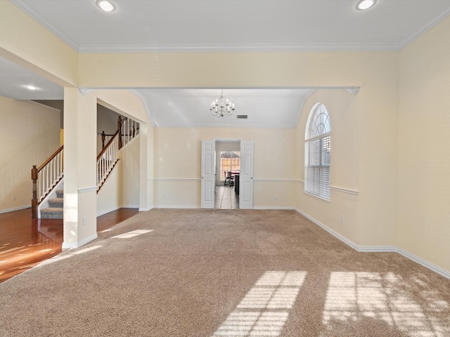 carpeted spare room featuring an inviting chandelier and crown molding