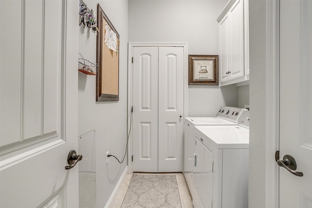 laundry area featuring light tile patterned flooring, cabinets, and separate washer and dryer