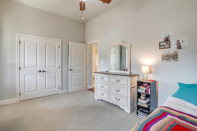 carpeted bedroom with ceiling fan and a closet