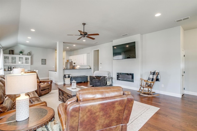 living room with lofted ceiling, hardwood / wood-style floors, and ceiling fan