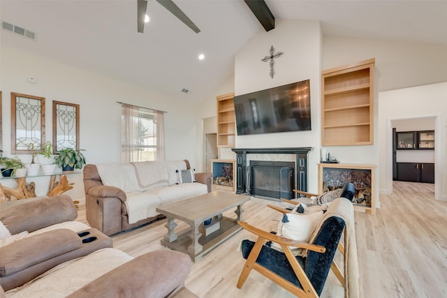 living room with light hardwood / wood-style floors, high vaulted ceiling, beamed ceiling, and ceiling fan