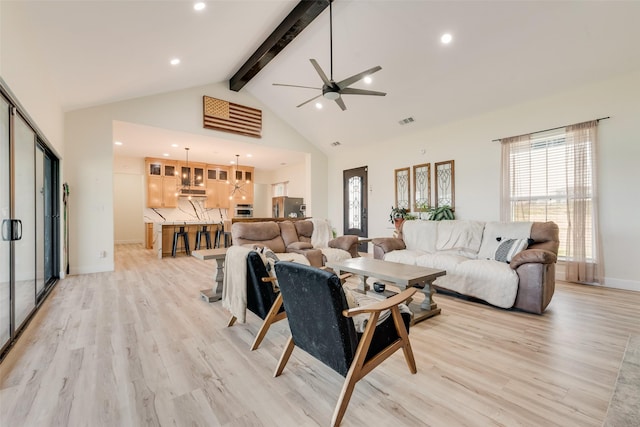 living room featuring ceiling fan, high vaulted ceiling, light hardwood / wood-style floors, and beam ceiling