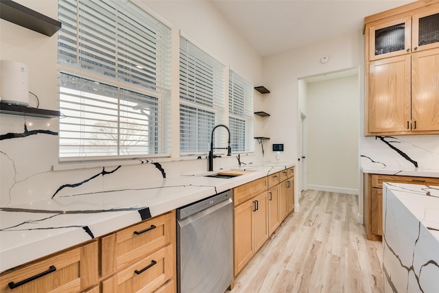 kitchen with stainless steel dishwasher, light hardwood / wood-style flooring, sink, and light brown cabinetry