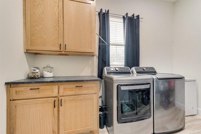 laundry room featuring independent washer and dryer and cabinets