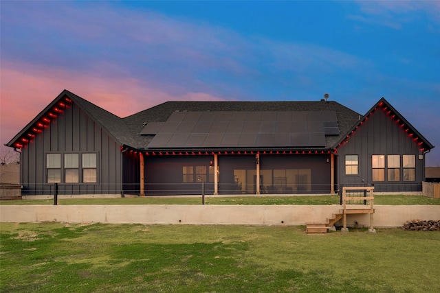 view of front facade with a lawn and solar panels