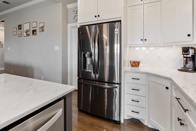 kitchen with ornamental molding, white cabinets, dark wood-style flooring, stainless steel appliances, and backsplash