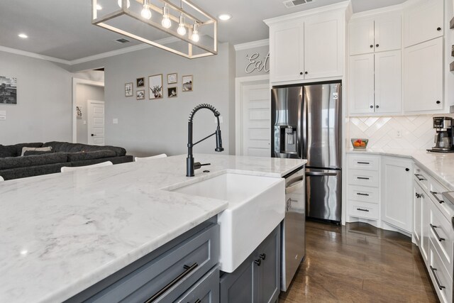 kitchen with a sink, recessed lighting, crown molding, and stainless steel appliances