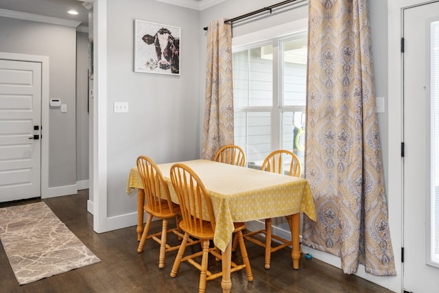 dining area featuring baseboards, crown molding, and dark wood finished floors