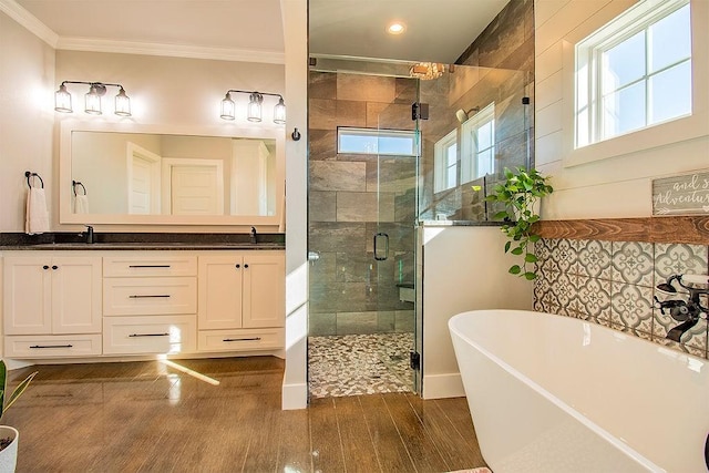 bathroom featuring independent shower and bath, crown molding, hardwood / wood-style floors, and vanity