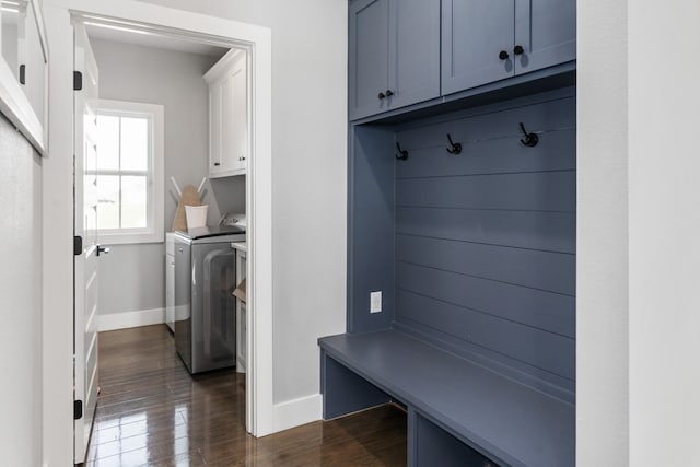 mudroom featuring dark wood-type flooring, washing machine and clothes dryer, and baseboards