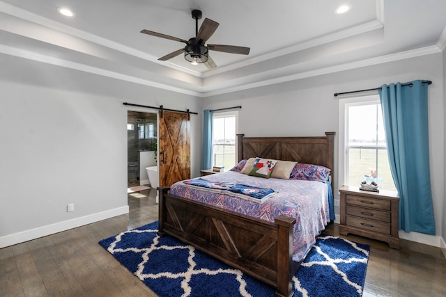 bedroom featuring crown molding, a tray ceiling, baseboards, and a barn door