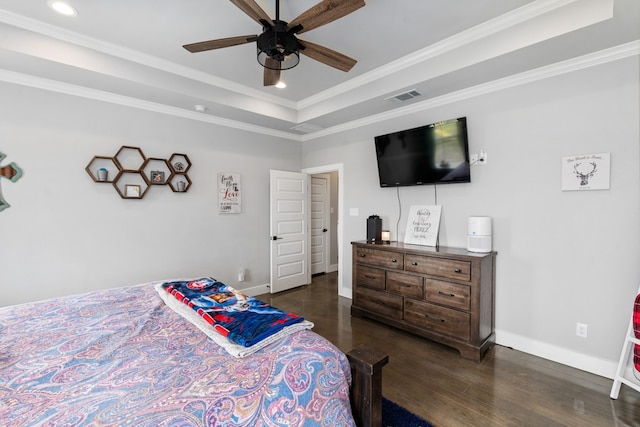 bedroom with crown molding, baseboards, a raised ceiling, and dark wood finished floors