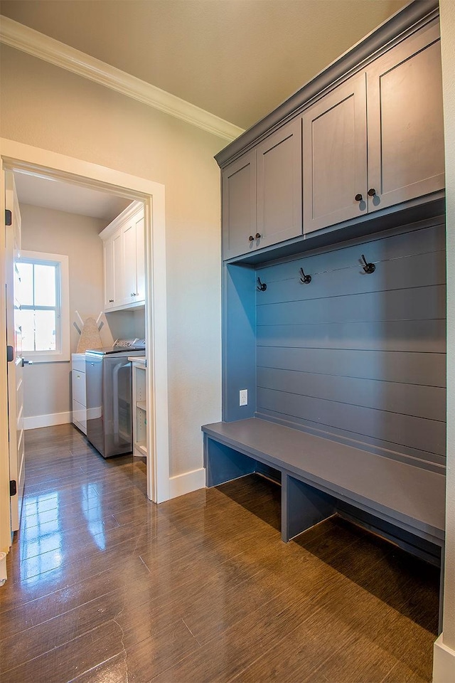 mudroom with crown molding, dark wood-type flooring, and washing machine and dryer