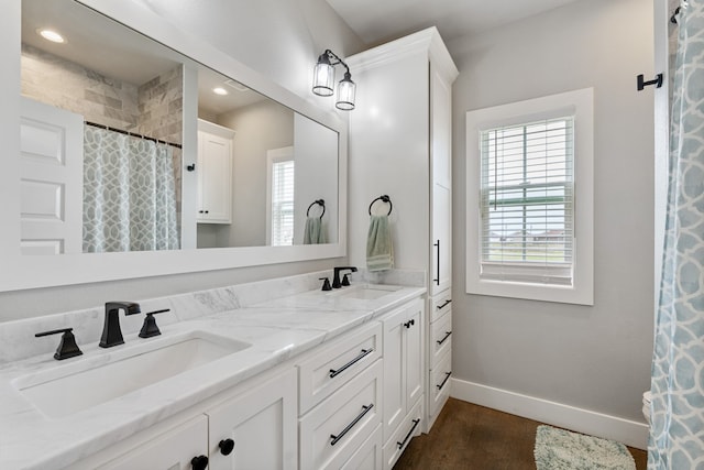 bathroom featuring baseboards, a sink, and plenty of natural light