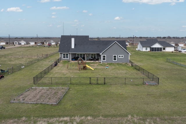 exterior space featuring a garden, a residential view, fence, and a lawn