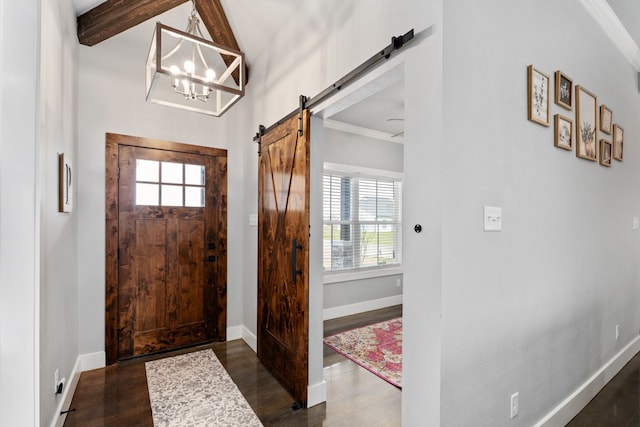 foyer featuring a healthy amount of sunlight, dark wood-style flooring, baseboards, and a barn door