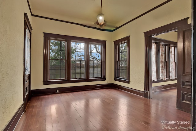 empty room featuring crown molding and dark hardwood / wood-style floors