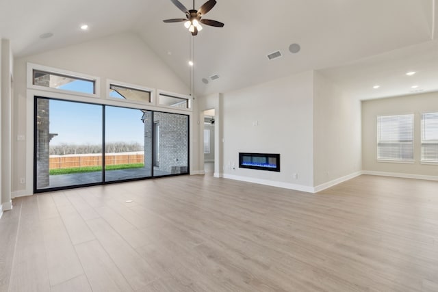 120 Bristol Ln, Azle, TX 76020 - unfurnished living room featuring light wood-style flooring, ceiling fan, a glass covered fireplace, and high vaulted ceiling