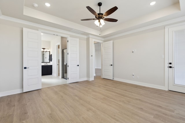 120 Bristol Ln, Azle, TX 76020 - unfurnished bedroom featuring a tray ceiling, light wood-type flooring, recessed lighting, and ensuite bath