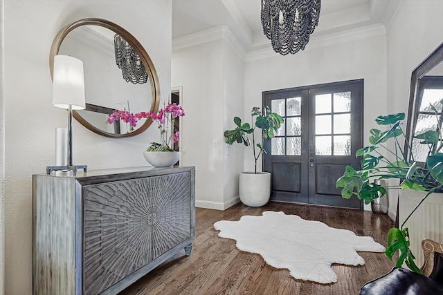 foyer with dark wood-type flooring, ornamental molding, and french doors