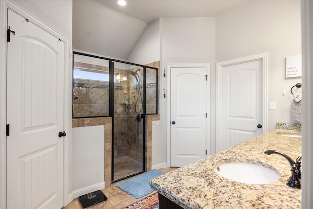 bathroom featuring a shower with door, vanity, lofted ceiling, and tile patterned flooring