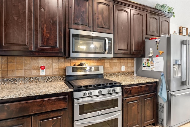 kitchen featuring light stone countertops, appliances with stainless steel finishes, dark brown cabinets, and backsplash