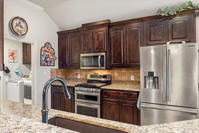 kitchen with tasteful backsplash, washing machine and clothes dryer, dark brown cabinetry, stainless steel appliances, and light stone countertops