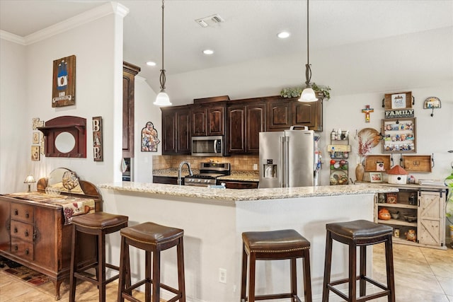 kitchen featuring decorative backsplash, dark brown cabinetry, kitchen peninsula, stainless steel appliances, and light stone countertops