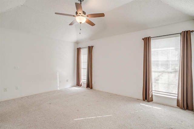 empty room featuring ceiling fan, light carpet, and a textured ceiling