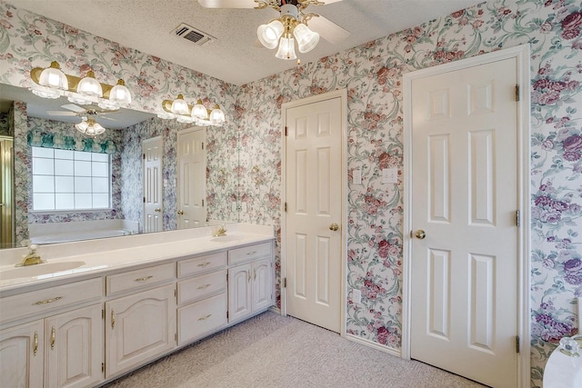 bathroom with vanity, ceiling fan, and a textured ceiling