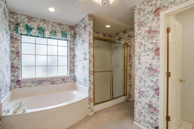 bathroom with a healthy amount of sunlight, separate shower and tub, and a textured ceiling