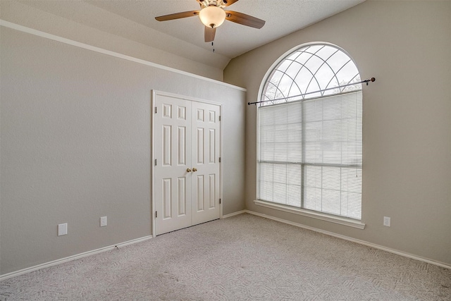 empty room with ceiling fan, light colored carpet, and a healthy amount of sunlight