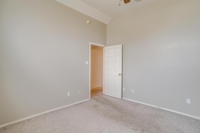 empty room with vaulted ceiling, light carpet, and ceiling fan