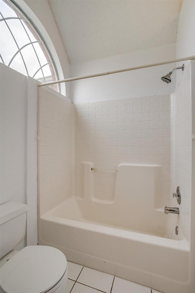 bathroom featuring tile patterned flooring, shower / washtub combination, and toilet