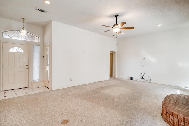 carpeted foyer entrance with ceiling fan and a textured ceiling