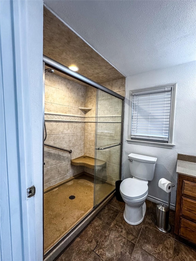 bathroom with toilet, vanity, a textured ceiling, and walk in shower