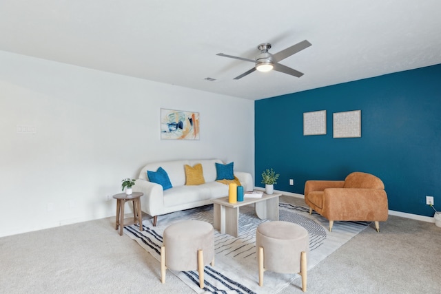 carpeted living area featuring a ceiling fan, visible vents, and baseboards