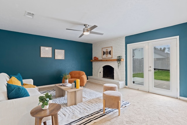 carpeted living area with baseboards, visible vents, a ceiling fan, french doors, and a fireplace