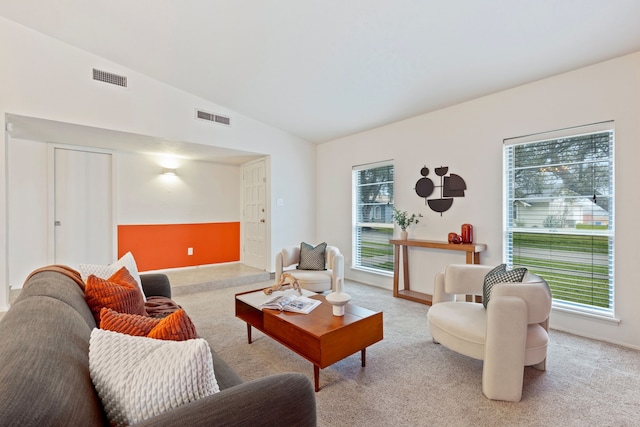 carpeted living room featuring visible vents and vaulted ceiling