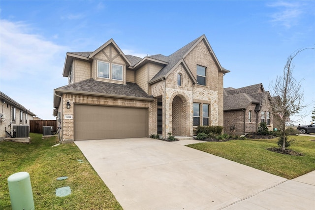 view of front of home with a garage, central AC, and a front lawn