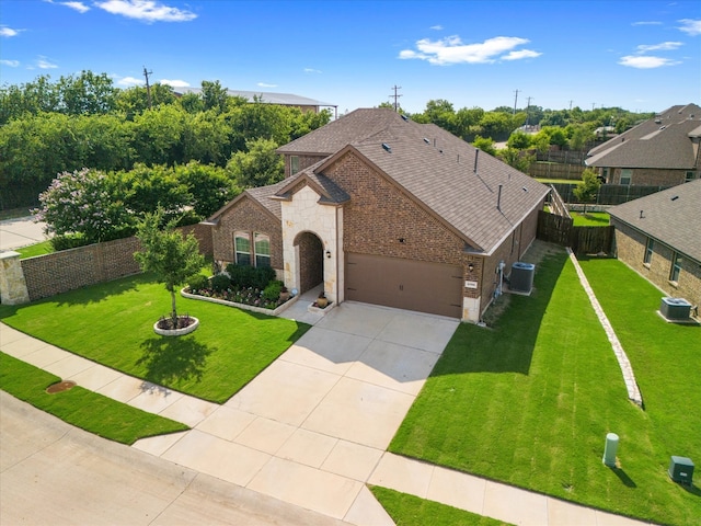 view of front of property featuring central AC, concrete driveway, a front yard, a shingled roof, and brick siding