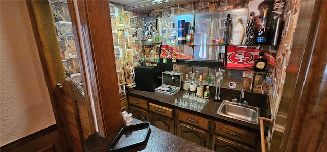 bar featuring sink and dark brown cabinets