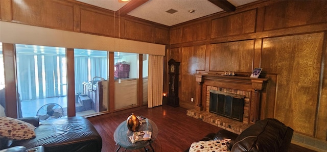 living room featuring coffered ceiling, dark hardwood / wood-style floors, a fireplace, and wood walls