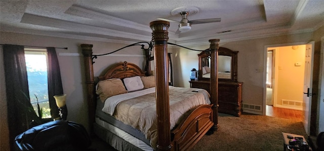 carpeted bedroom featuring crown molding, a textured ceiling, and a tray ceiling