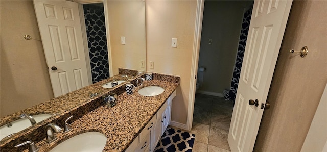 bathroom featuring tile patterned floors, vanity, and toilet