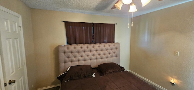 bedroom with ceiling fan and a textured ceiling