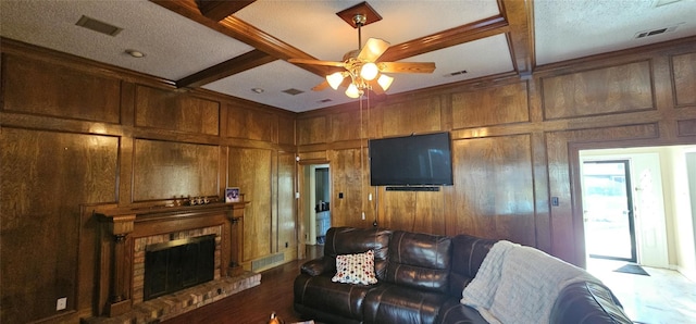 living room with a fireplace, coffered ceiling, beam ceiling, and wood walls