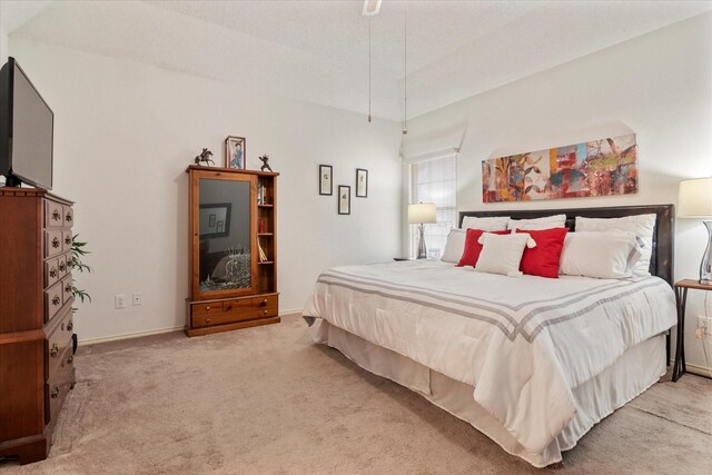 bedroom featuring vaulted ceiling and light carpet