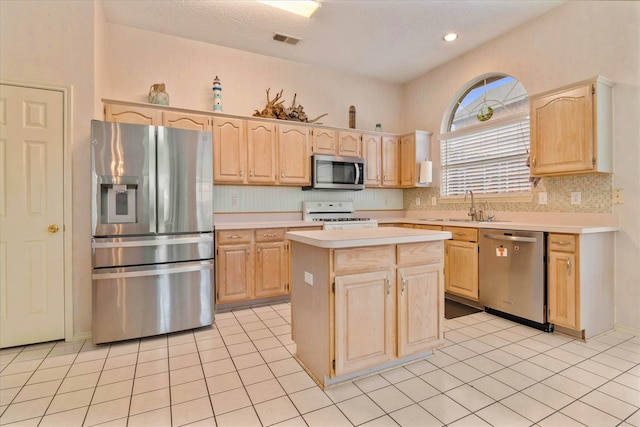 kitchen featuring a kitchen island, appliances with stainless steel finishes, sink, and light brown cabinets